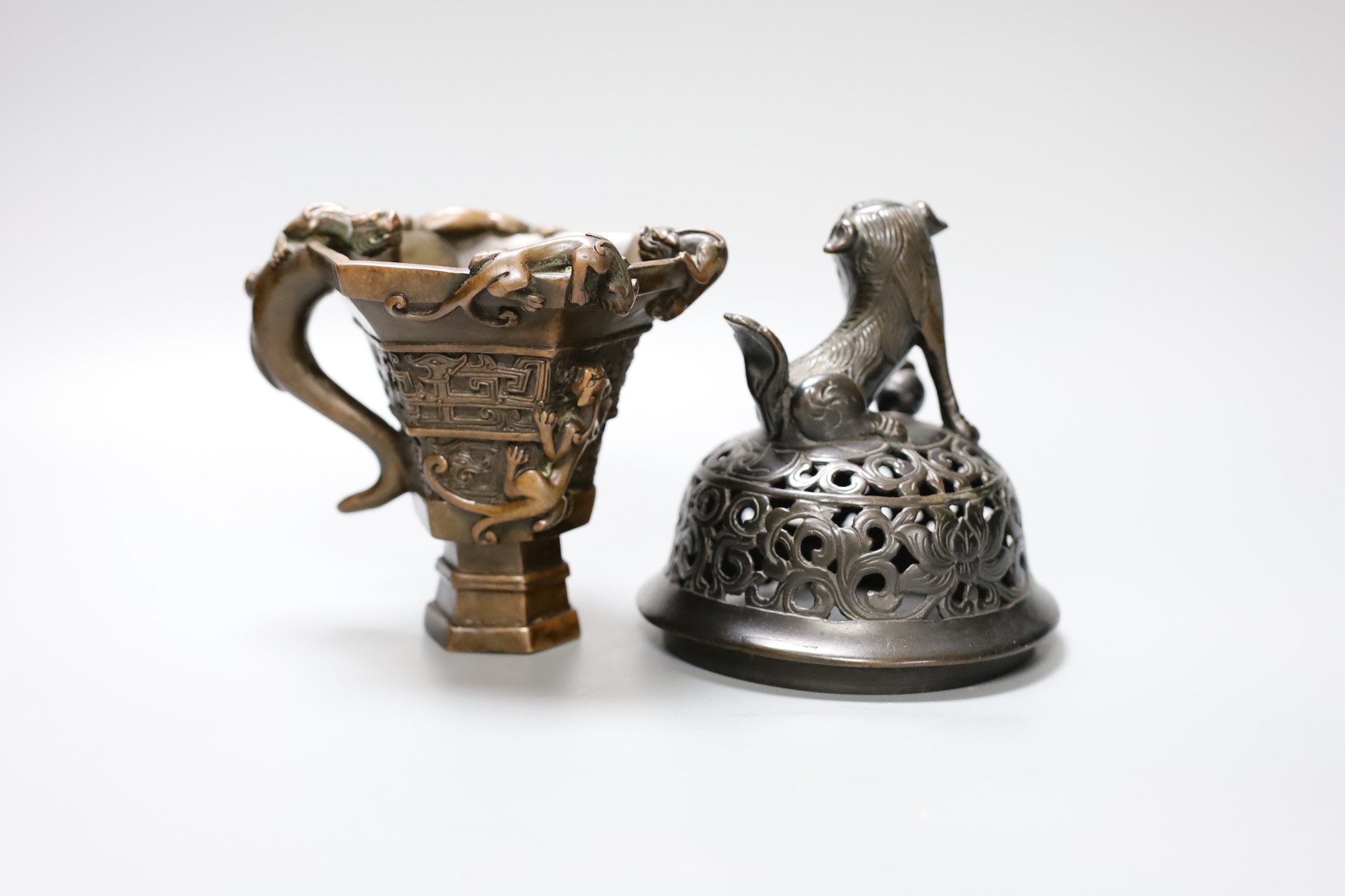 A Chinese bronze handled libation cup, together and a bronze cover with pierced decoration and seated dog, tallest 12cm